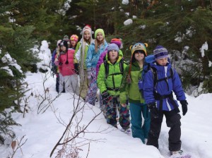 The group trekked through the woods in the snow.