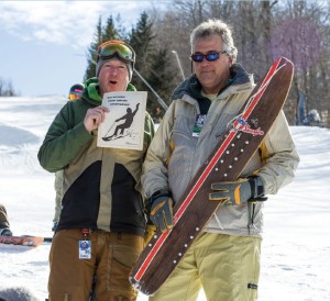 Hayes (left) and Graves introduce the Snurfer Challenge, with a snurfer, an early ancestor of the snowboard.