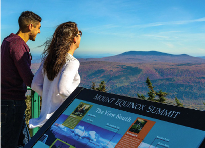 This couple is standing on the summit of Mt. Equinox, looking across the valley at Stratton Mountain, at 3,940 feet, the highest mountain in Southern Vermont.