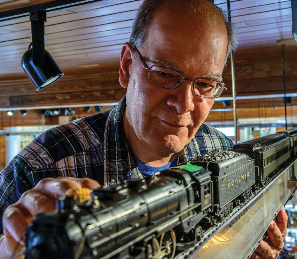 John Schaub fine tunes one of his model train creations.