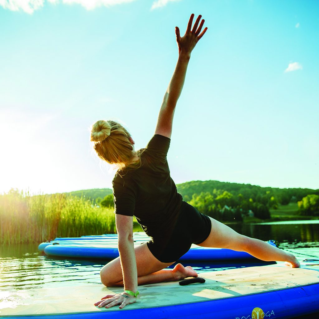 girl doing yoga on standup paddleboard