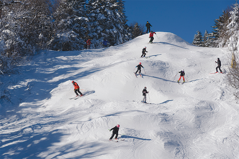 group of ski students skiing moguls