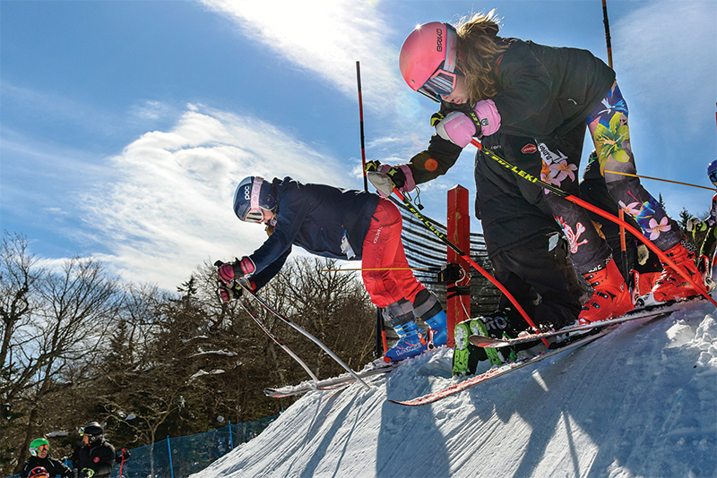 young girls a starting gate on skis