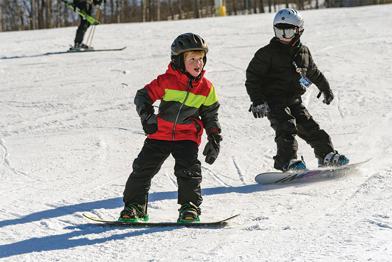 young boy riding a snowboard